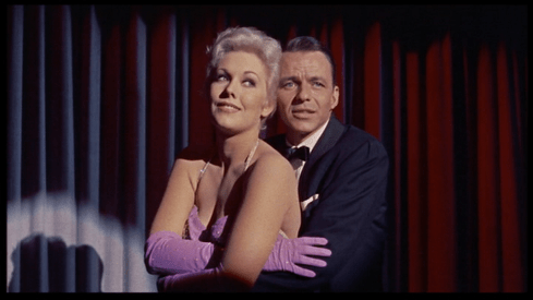 Frank Sinatra squeezes Kim Novak as he sings on stage in this frame from Pal Joey (1957)